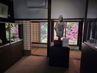 紅葉を背に静かに佇む仏陀像