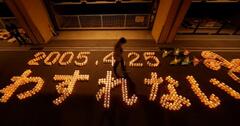 尼崎ＪＲ脱線事故から１９年となるのを前に、追悼行事でともされたろうそくで浮かび上がった「２００５・４・２５　わすれない」の文字＝２４日夜、兵庫県尼崎市