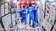 北京の宇宙飛行管制センターのモニターに映し出された、宇宙ステーション「天宮」で抱き合う神舟１７号と１８号の飛行士＝２６日（新華社＝共同）