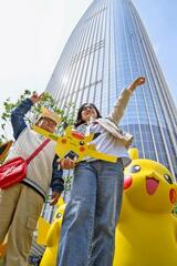 ２６日、ソウルのロッテワールドタワー前に登場したピカチュウの人形と、記念撮影を楽しむ人たち（共同）