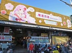 センター入口に描かれたサクラエビを擬人化した美少女キャラ「シェンイン」＝２月下旬、台湾東港の漁産品直販センター