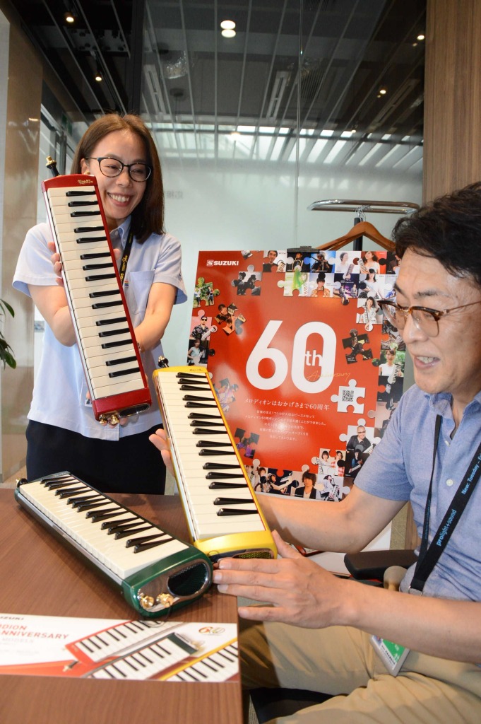 誕生６０周年を記念した限定色モデルの「メロディオン」をＰＲする多田和修執行役員（右）ら＝浜松市中区の鈴木楽器製作所