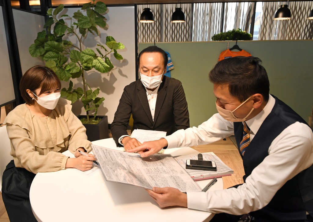 実況資料を囲み対談する（左から）山﨑加奈、大石岳志、岡村久則の各アナウンサー