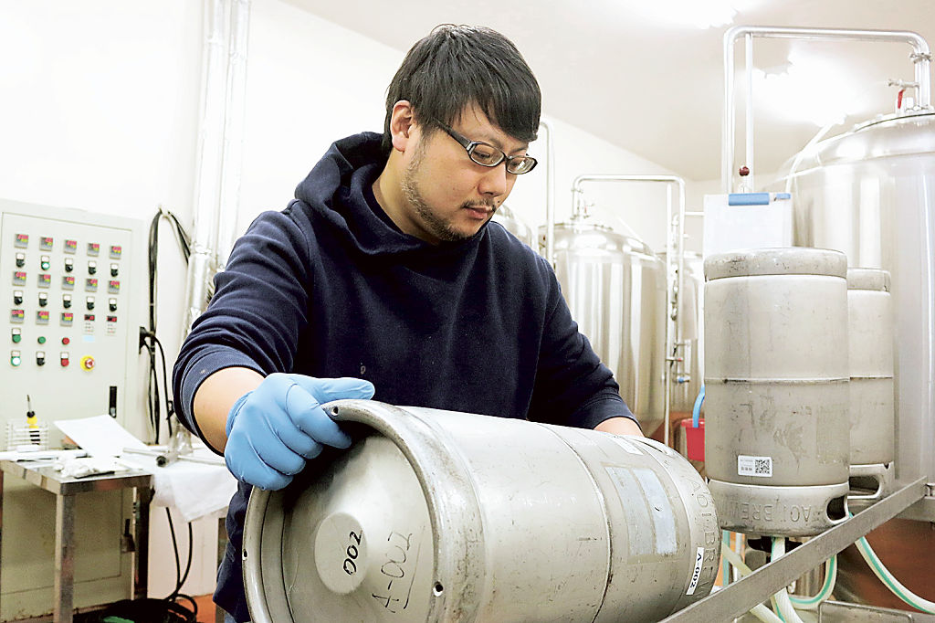 ビールを詰めるケグ（容器）を洗浄する星野賢人さん＝２月中旬、静岡市葵区のアオイブリューイング