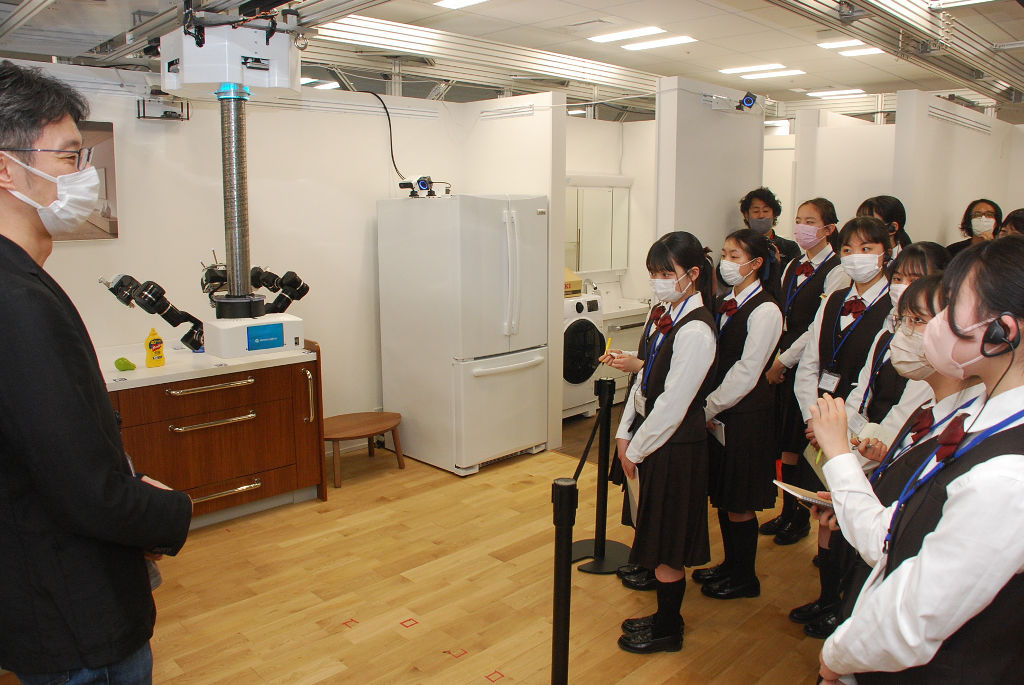 住居スペースで物を運ぶロボットの開発現場を見学する生徒たち＝東京都中央区のウーブン・プラネット・ホールディングス