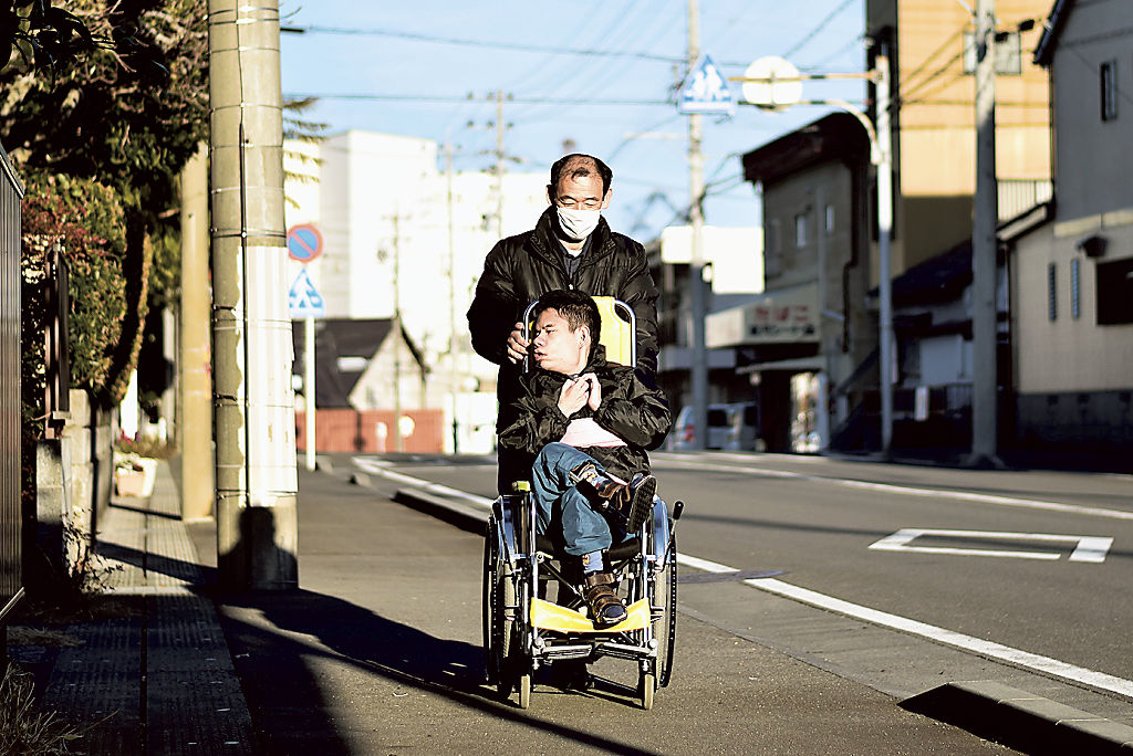 隼さんと一緒に自宅付近を散歩する渡辺裕之さん＝１月下旬、静岡市清水区
