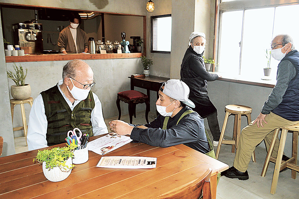 来店した住民と交流する高橋一美代表(手前右)=15日午後、熱海市伊豆山のあいぞめ珈琲店
