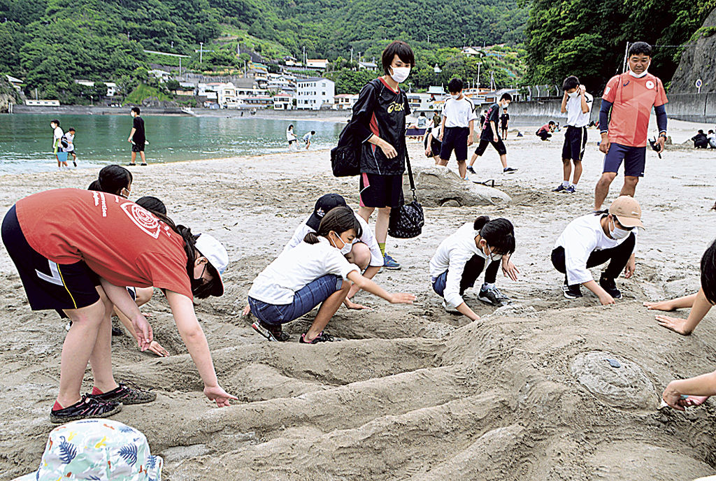 サンドアート制作を楽しむ生徒たち＝松崎町の岩地海岸