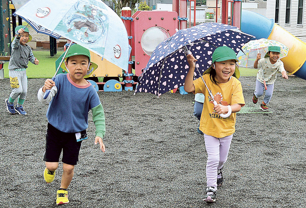 雨にもコロナにも負けない―。屋外での脱マスクを採用する保育園で元気に遊ぶ園児ら=16日午前、焼津市内