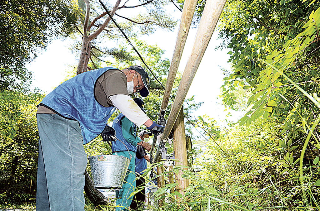 手すりを磨く会員たち＝浜松市浜北区の県立森林公園