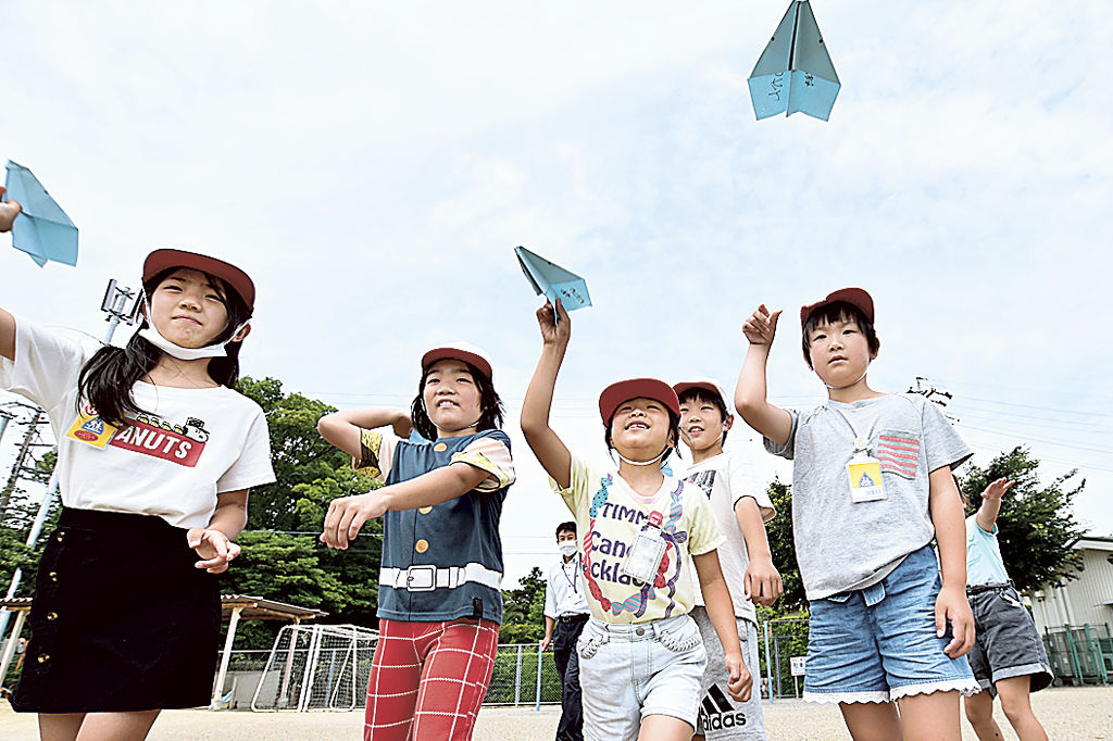 夢を乗せた紙飛行機を飛ばす児童＝浜松市南区の飯田小（写真の一部を加工しています）