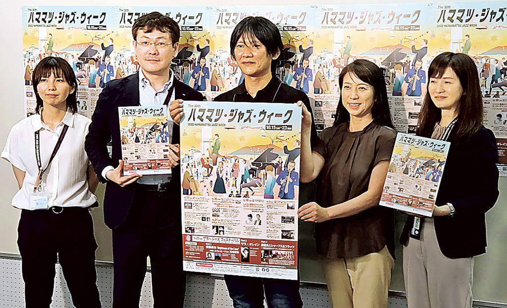 ポスターを掲げ、開催をアピールする事務局のメンバー＝浜松市役所