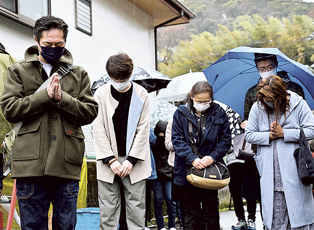 雨の中、犠牲者の冥福を祈って黙とうする遺族ら＝４月３日午前、熱海市伊豆山