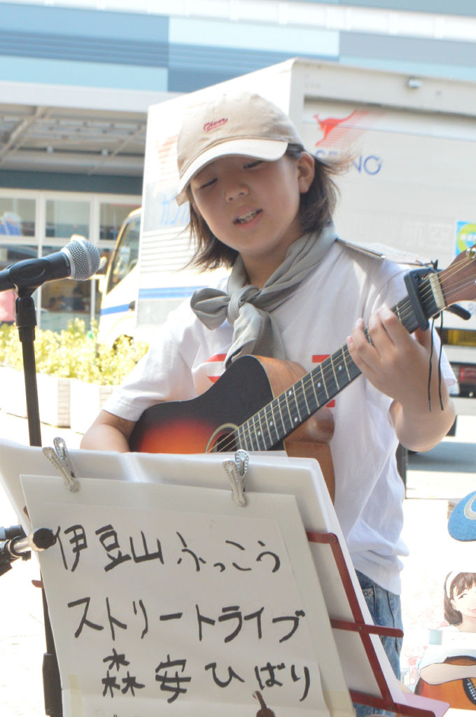 伊豆山を応援しようと路上で歌を披露する森安ひばりさん＝２日午後、ＪＲ熱海駅前
