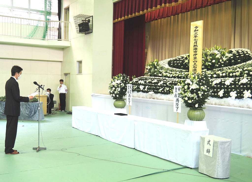 追悼式で弔辞を読み上げる斉藤栄熱海市長（左）＝３日午前、熱海市立伊豆山小