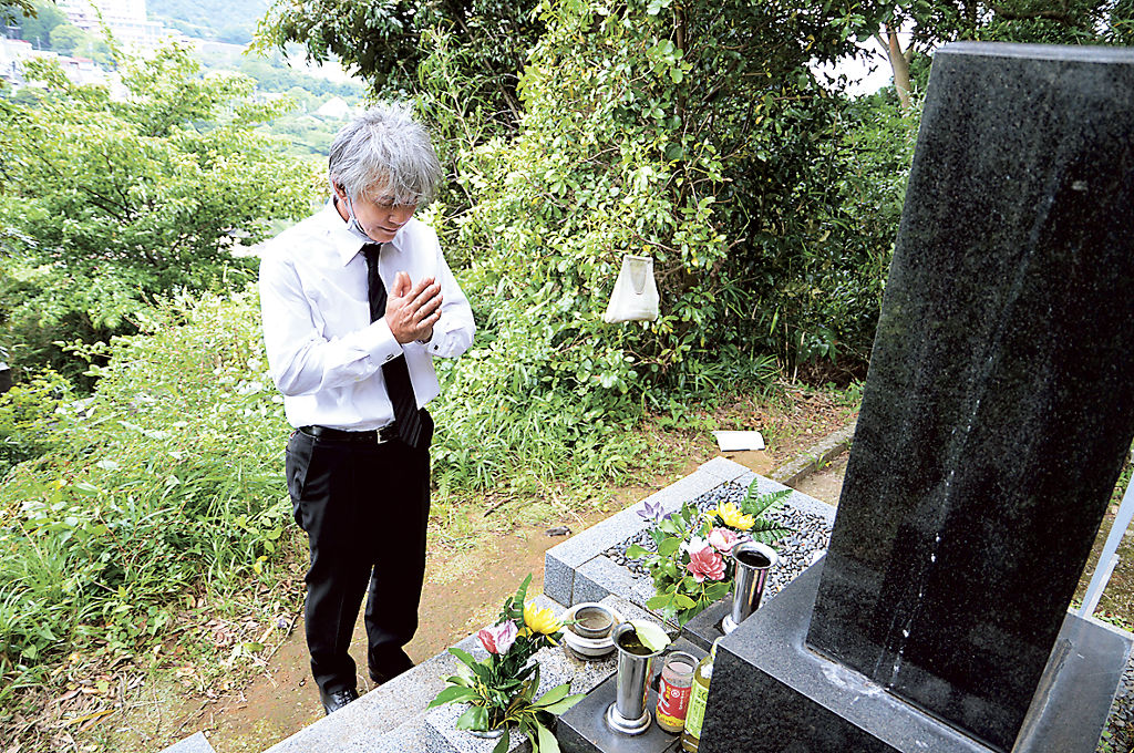 土石流で亡くなった母・笑子さんのことを思い、墓前で手を合わせる草柳孝幸さん＝３日午前、熱海市伊豆山