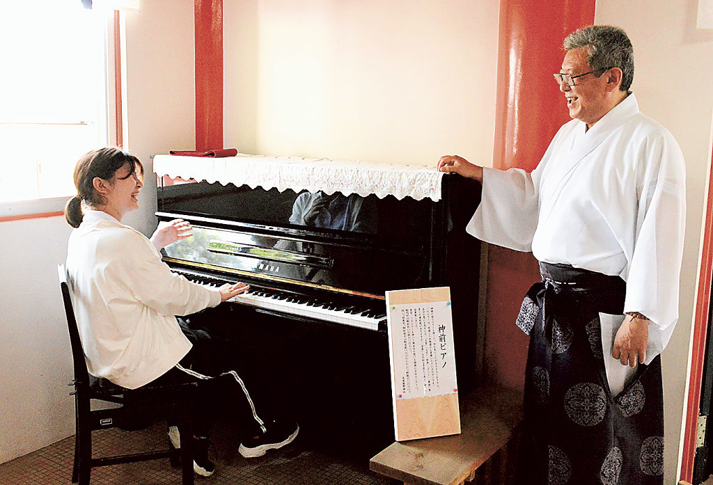 拝殿に常設されたヤマハのピアノ。戸塚昌宏宮司（右）は「少しでも心が安らぐ場所になれば」と期待を込める＝６月２５日、浜松市南区の高塚熊野神社