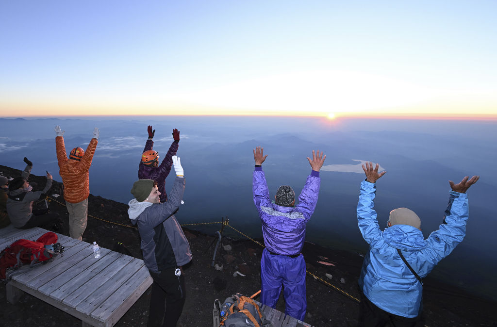 万歳をして御来光を迎える登山者＝１日午前４時３３分、富士山頂（東部総局・山川侑哉）