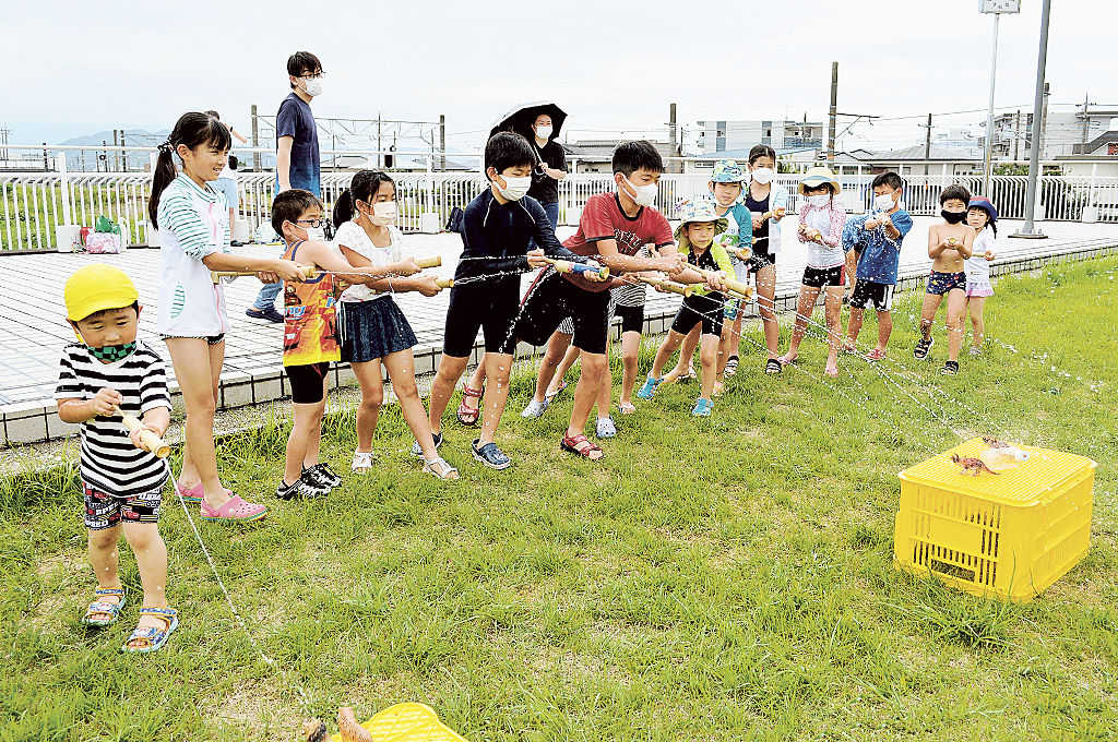 的をめがけて水鉄砲で一斉に水を放つ子どもたち＝長泉町のコミュニティながいずみ