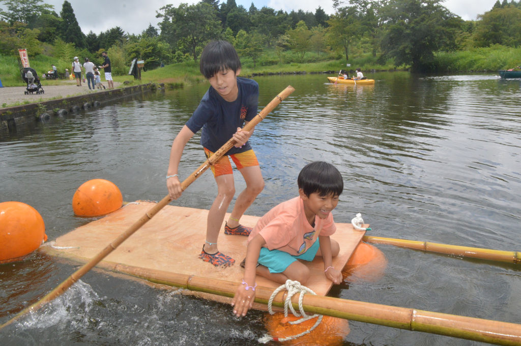 手作りのいかだで池をこぎ出す子どもたち＝富士市の富士山こどもの国