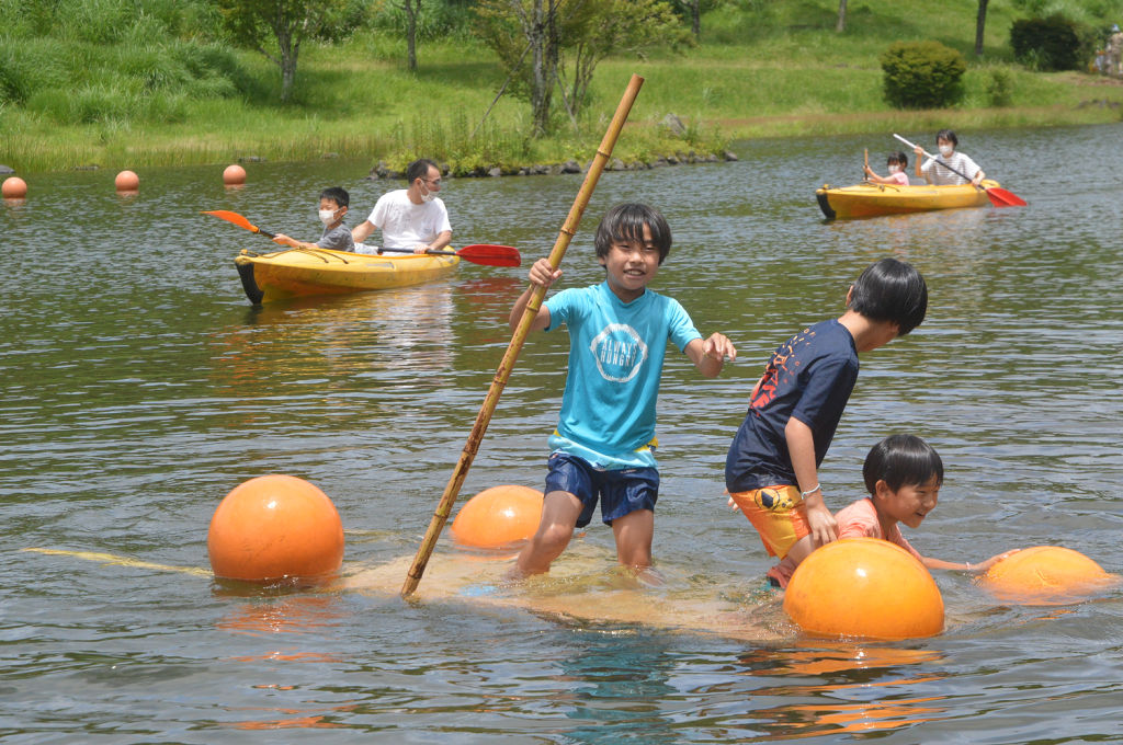 手作りのいかだで池をこぎ出す子どもたち＝富士市の富士山こどもの国