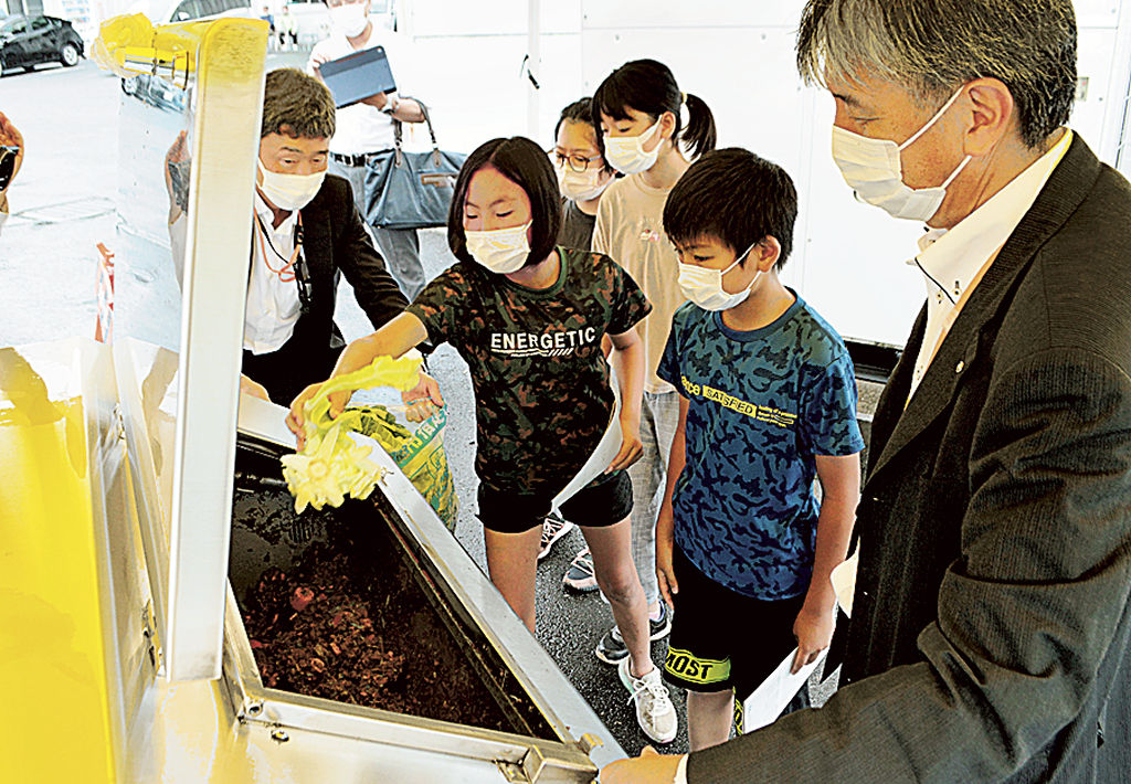 残った野菜を堆肥化する装置を見学する児童＝三島市の三島青果