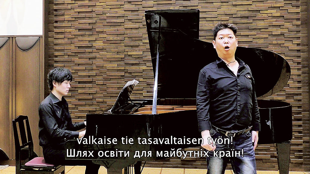 ユーチューブで配信している動画で、ウクライナに向けて歌唱するバリトン歌手の鈴木啓之さん（右）（本人提供）
