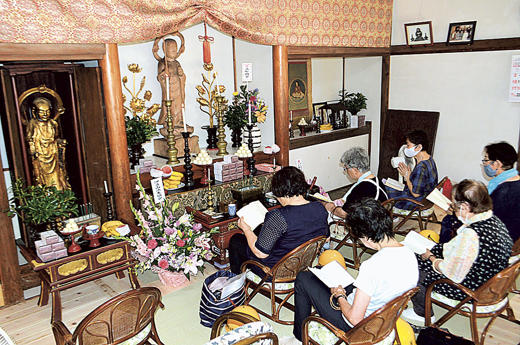 修復作業が完了した逢初地蔵堂で念仏を唱える地元の女性ら＝熱海市伊豆山