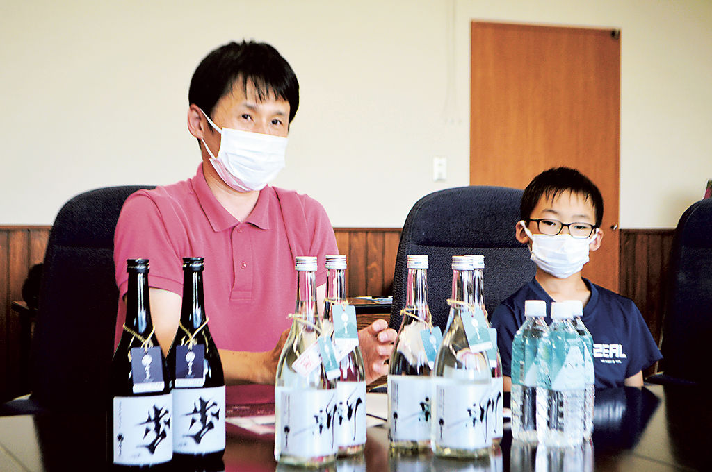 裾野産原料の焼酎発売を報告する「みしまや」の江森さん（左）＝裾野市役所
