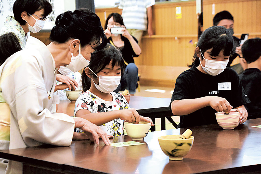 茶せんを使い抹茶をたてる子どもたち＝磐田市弥藤太島の市豊田福祉センター
