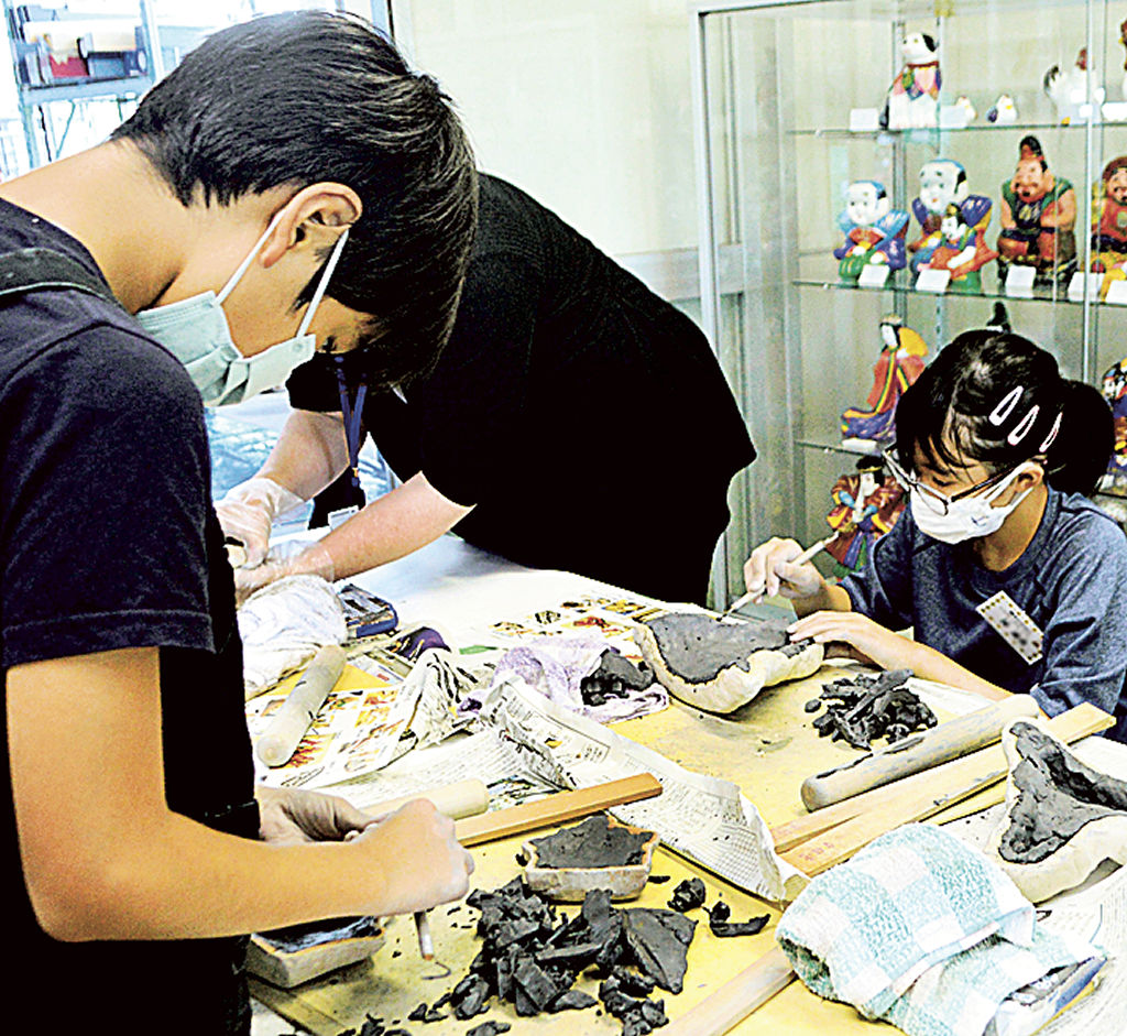 粘土を型にはめて焼きびなを制作する児童＝菊川市埋蔵文化財センター