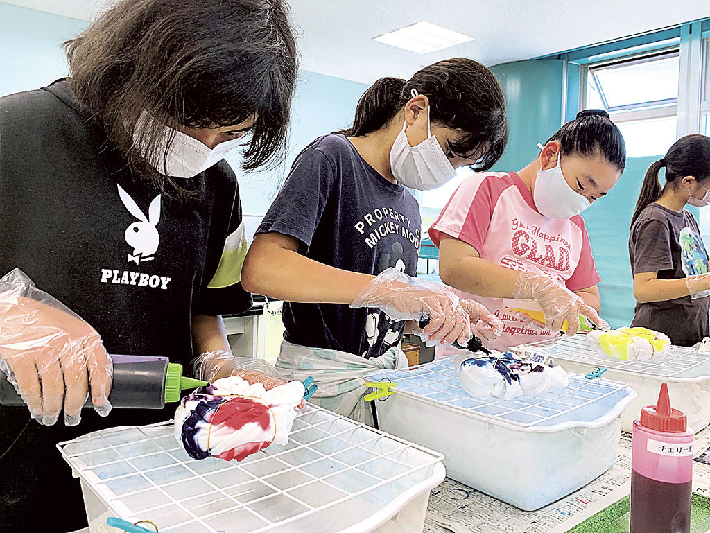 白いＴシャツに染料を染み込ませる子どもたち＝静岡市駿河区の静岡科学館る・く・る