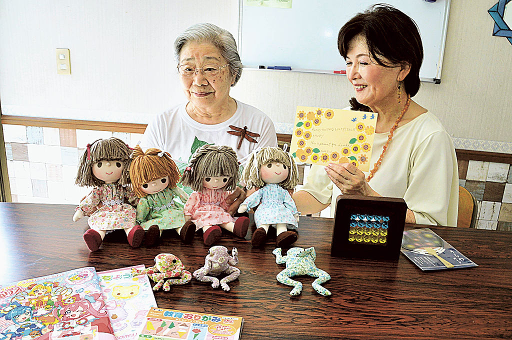 リンダちゃんのために作った人形を影山さんに託す鈴木さん（左）＝浜松市北区