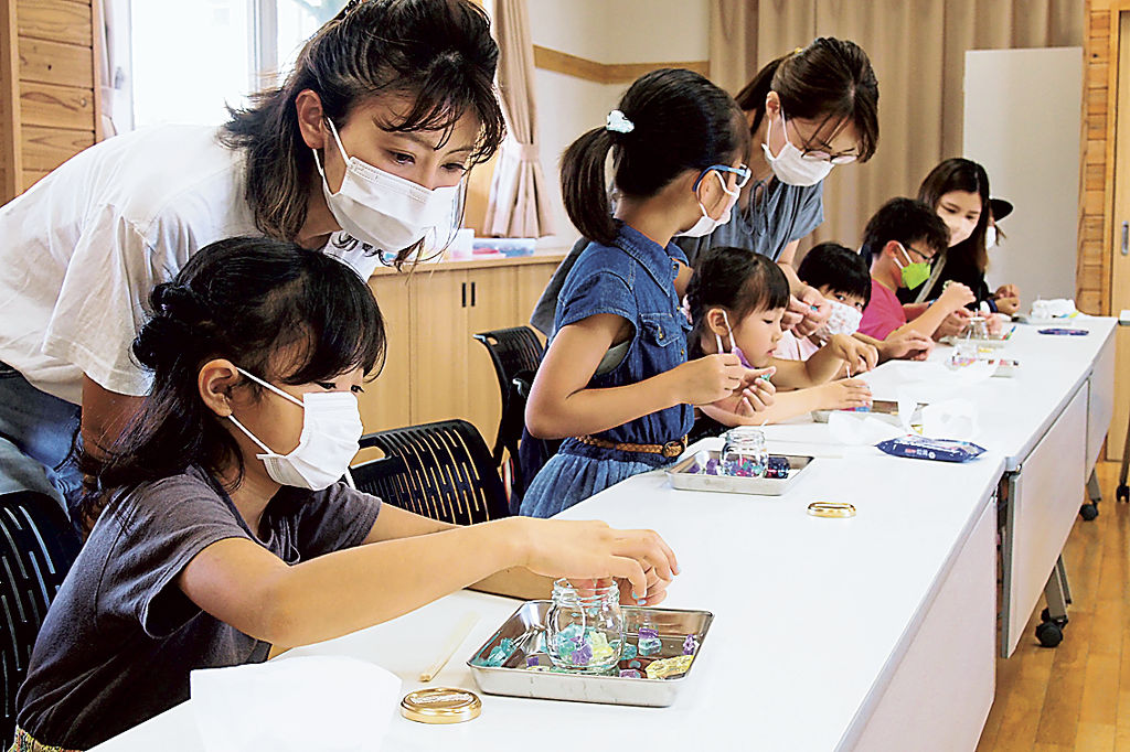 ろうのジェルの端材を使って、オリジナルのグラスキャンドルを作る参加者＝磐田市上新屋の新造形創造館