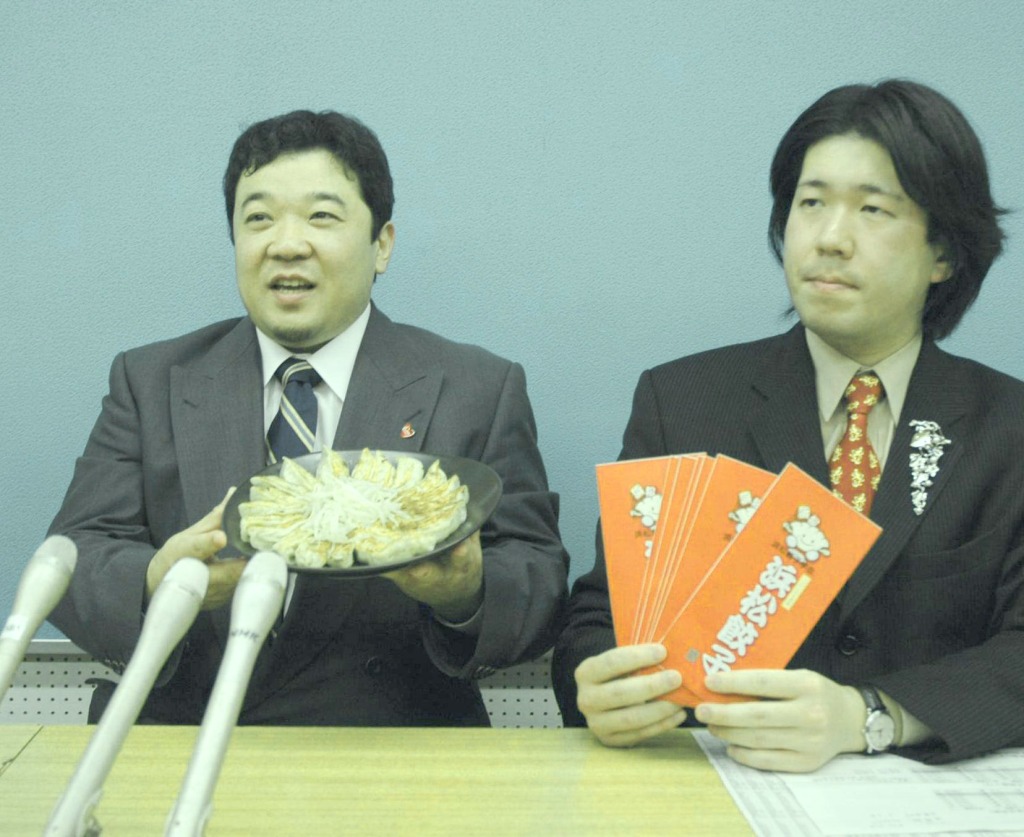 浜松餃子を手に“日本一”を宣言する古橋会長（左）＝浜松市役所