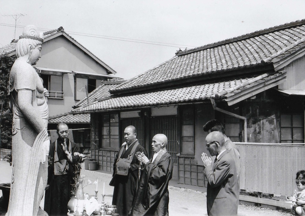 １９６３年ごろとみられる島田市の石材店での写真。後に賤機山に運ばれる観音像に手を合わせる伊藤福松さん（左から４人目）