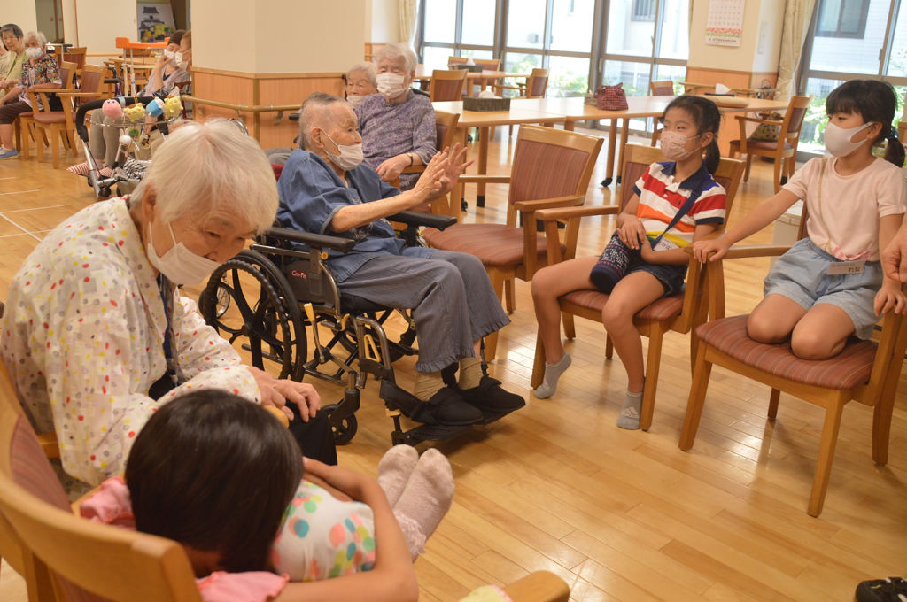 施設で高齢者と触れ合いながら過ごす児童たち＝７月下旬、浜松市中区の浜松中央長上苑