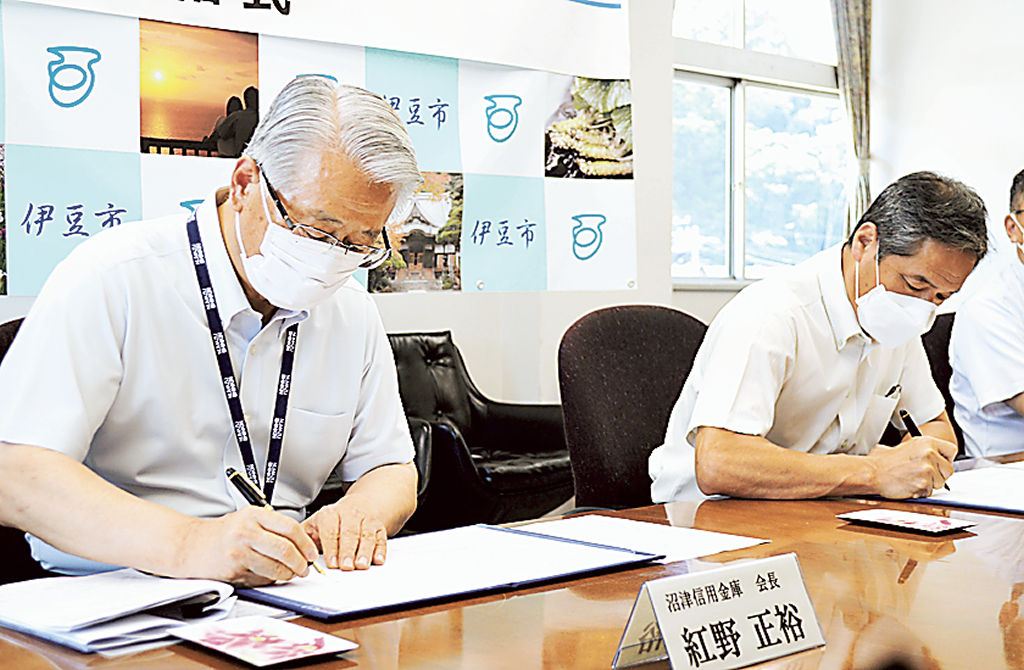 協定書に署名する紅野会長（左）と菊地市長＝伊豆市役所