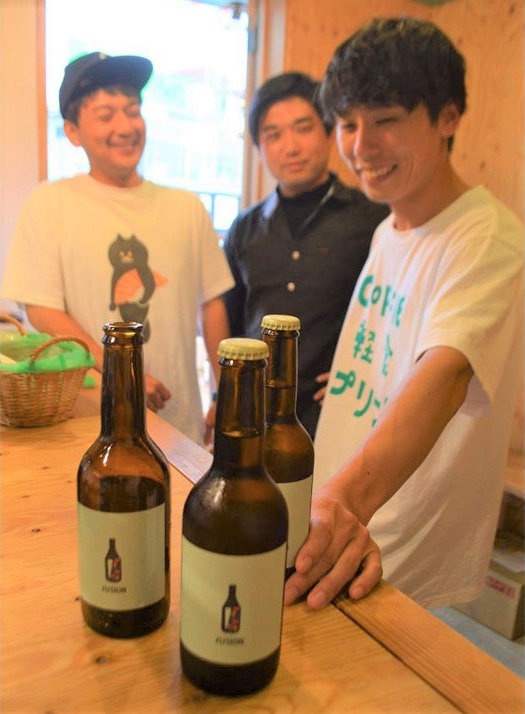 コーヒーを使ったクラフトビールを紹介する青木さん（右）ら＝島田市の駅前緑地