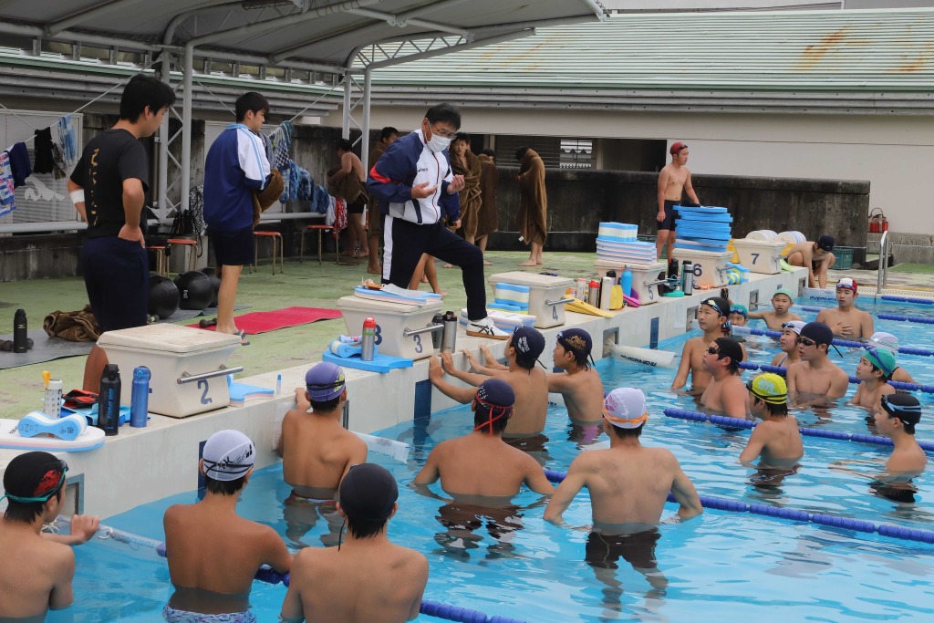 泳ぐ姿勢や練習のポイントについて指導員の助言を受ける部員ら＝５月下旬、掛川市の西中