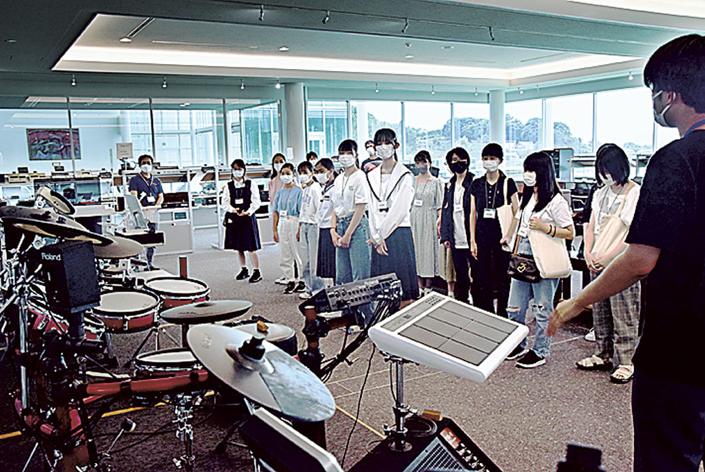 楽器が並ぶミュージアムを見学する生徒＝浜松市北区のローランド浜松研究所
