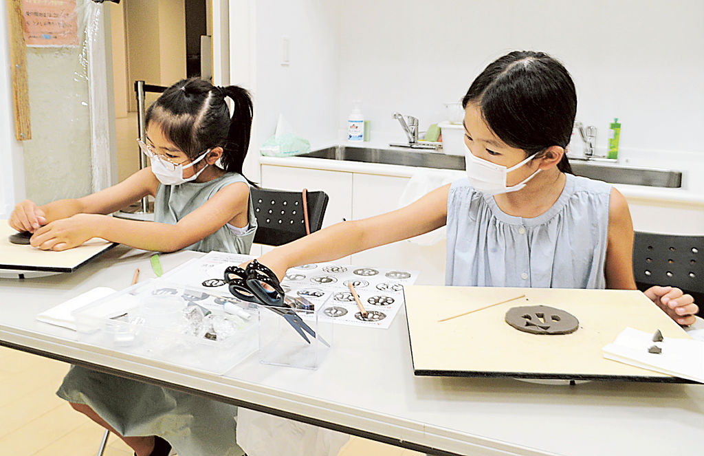 刀の鐔を模したコースターを制作する参加者＝静岡市葵区の市美術館