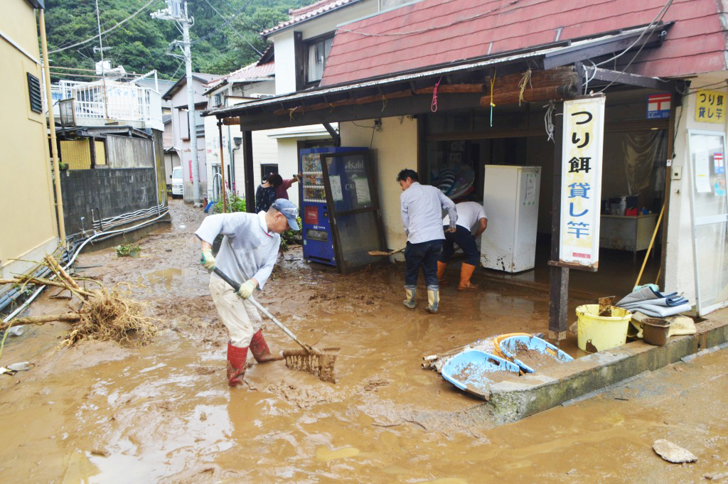 屋内に泥水が流れ込み、かき出し作業に追われる地元住民ら＝１４日午前、松崎町雲見