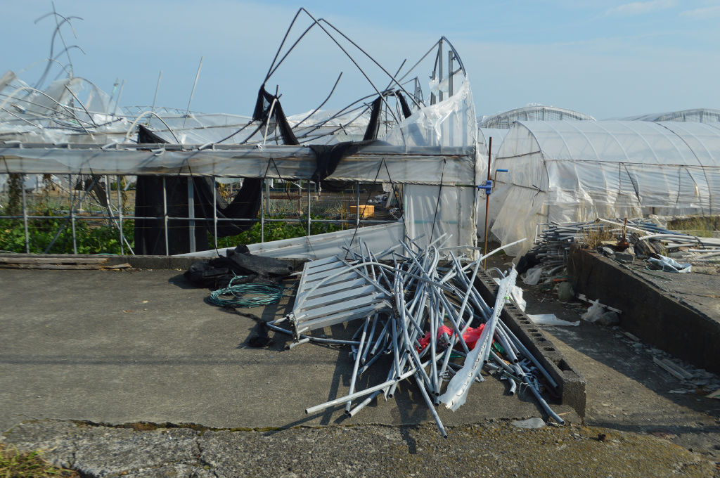 突風の影響で損壊したビニールハウスと片付けたパイプ＝静岡市駿河区青沢