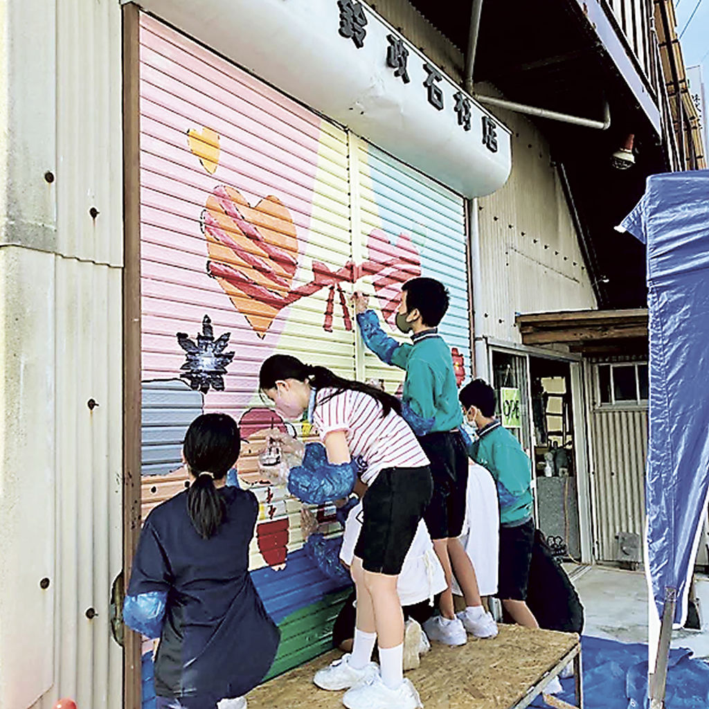 シャッターアートを制作する生徒ら＝静岡市葵区安倍口新田の鈴政石材（提供写真）