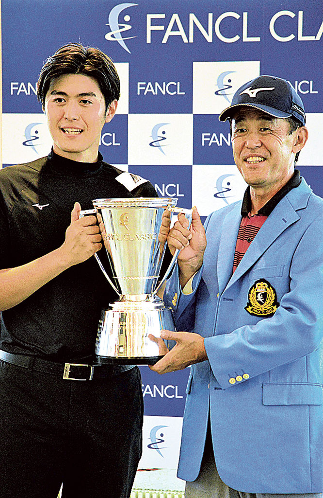今季初優勝を決めトロフィーを持つ鈴木亨（右）と息子の貴之さん＝裾野カンツリー倶楽部