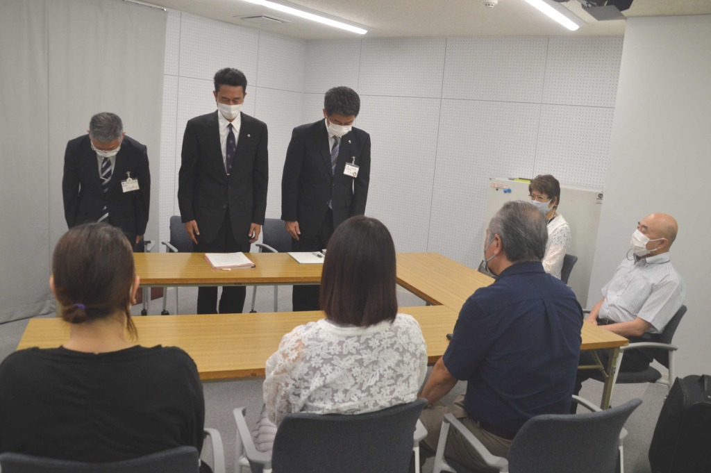 いじめ被害を訴えてきた女性（手前中央）と両親に謝罪する宮崎正教育長（奥中央）ら＝２３日午後、浜松市役所