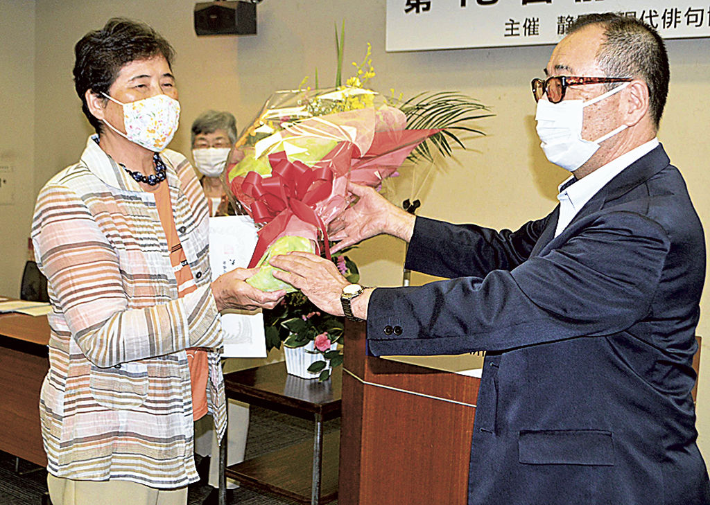大賞を受賞し花束を受け取る稲津さん（左）＝静岡市葵区のもくせい会館