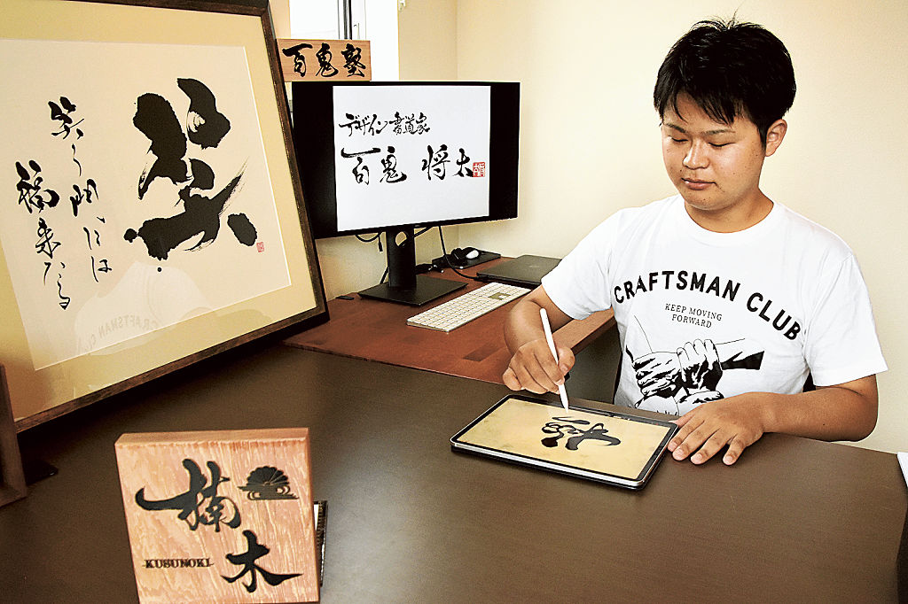 タブレット端末の画面に文字を書くスタイルで書道家として活動する百鬼将太さん＝８月下旬、磐田市内