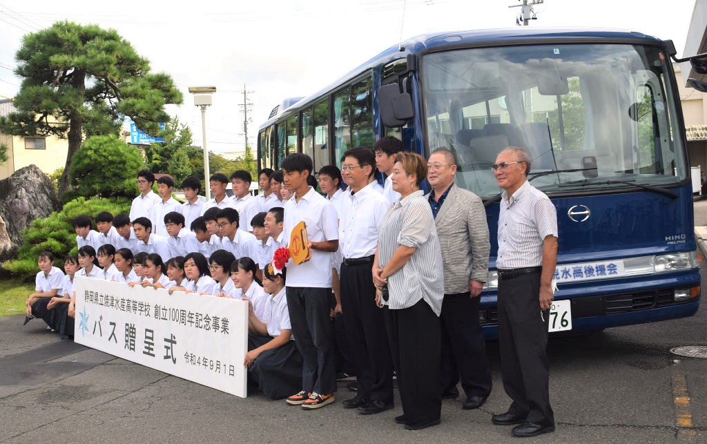 贈呈されたバスの前で記念撮影する生徒たち＝焼津市焼津の焼津水産高